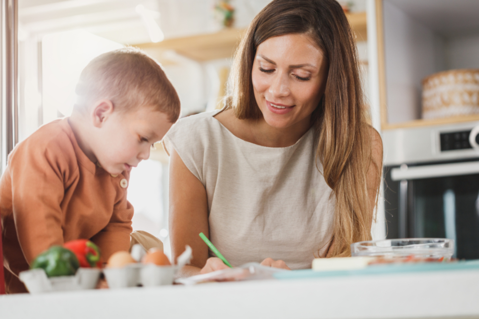 A mother and her young son at the kitchen table together